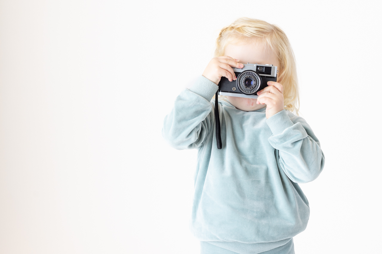 Jente på 4 år med fotoapparat tar bilde av fotografen